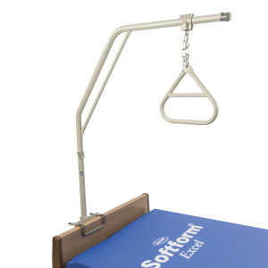 A hospital bed trapeze bar with a metal frame attached to the headboard. The trapeze has an overhead frame with a triangular handle hanging from a chain, designed to help patients reposition themselves. The mattress has a visible "Sofftform Excel" label.